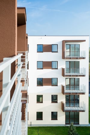 Block of modern apartments and condos with balconied overlooking a grass courtyard at a multi-unit investment property.