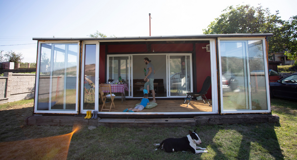 A typical shipping container home with a large front porch.